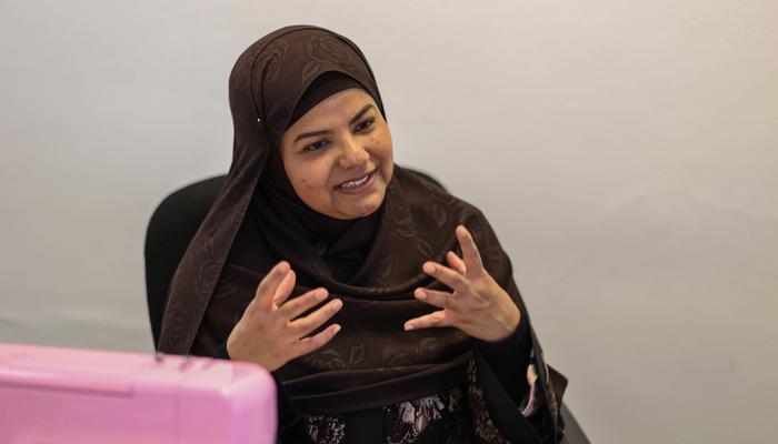 A woman supported by Maa Shanti smiles as she is talking