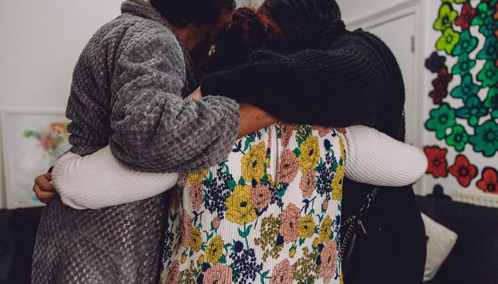 Women in a comforting huddle at charity Ella's